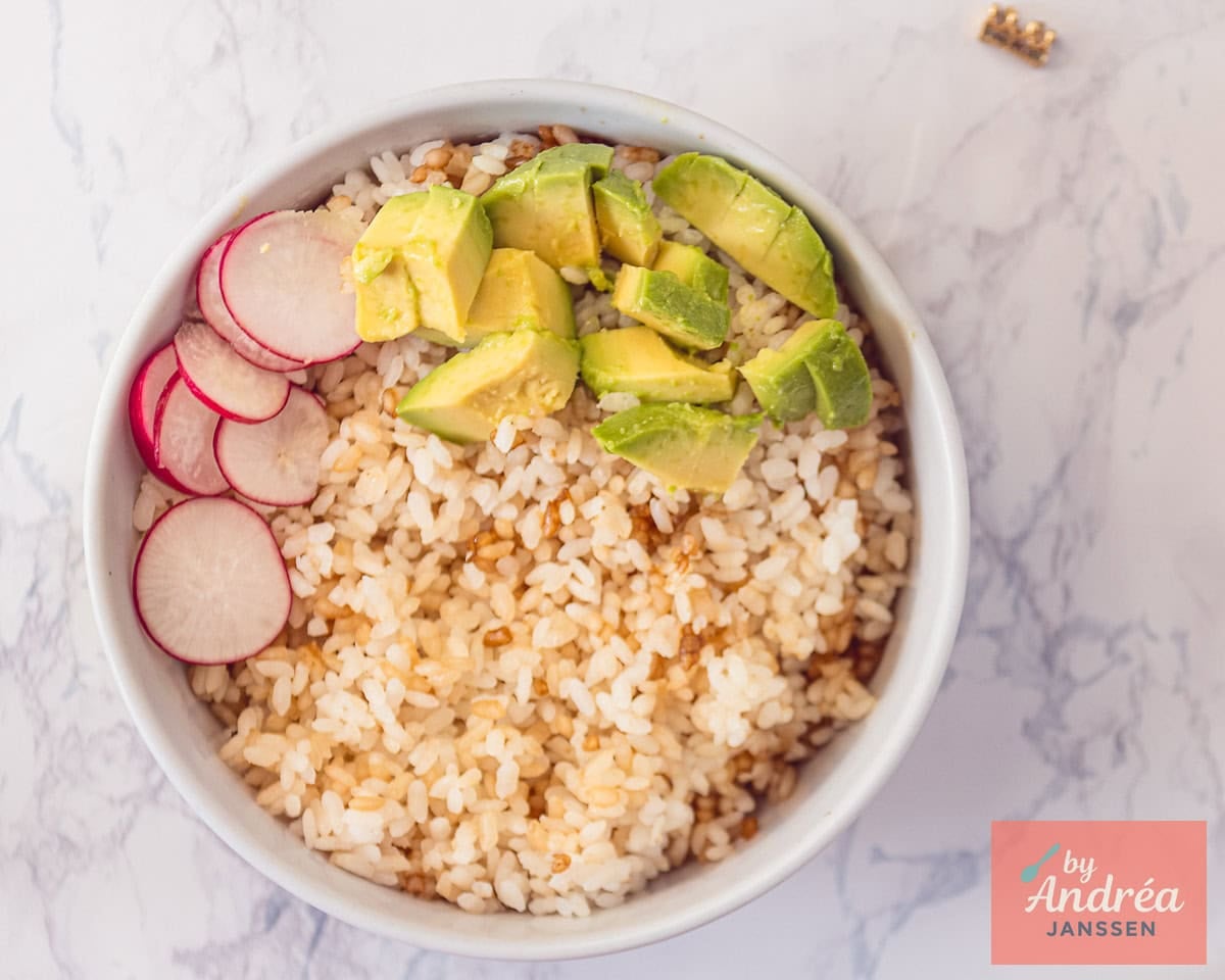 Bowl with sushi rice, radish slices and avocado