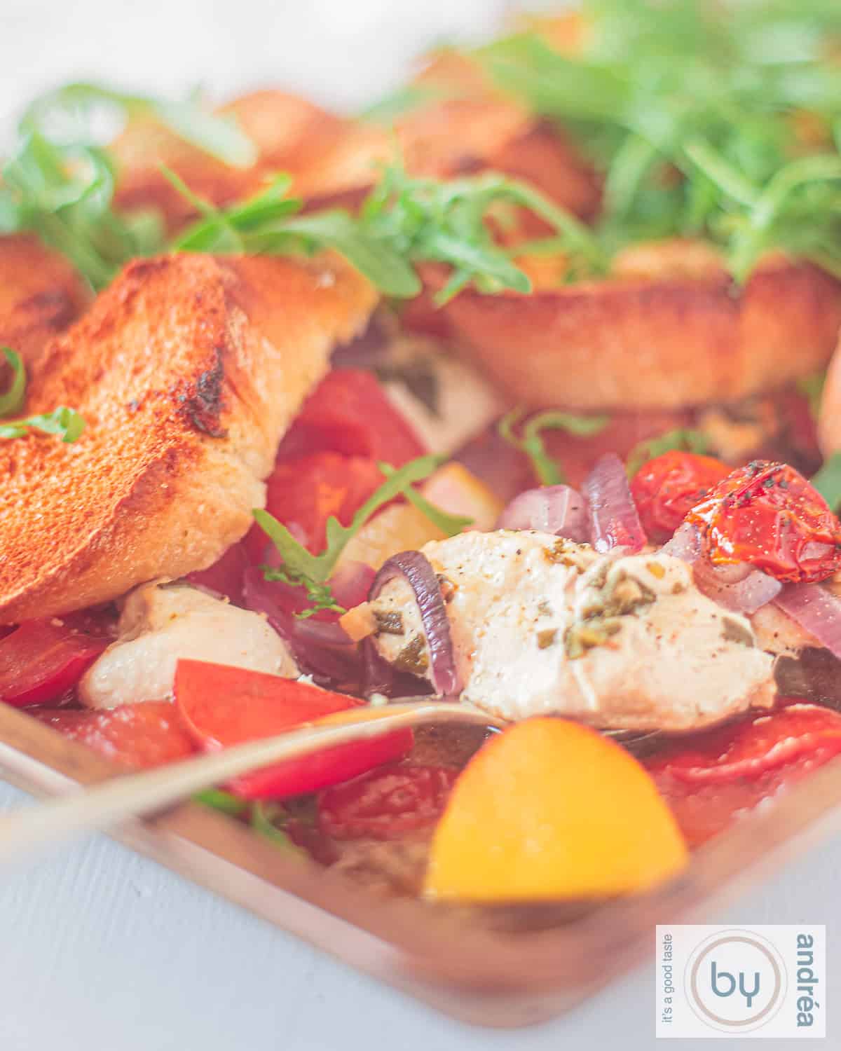 Italian casserole with chicken, lemon, tomato and arugula on a white background