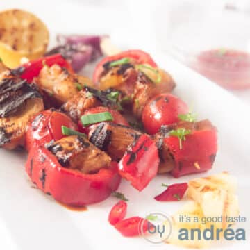 A square photo with three teriyaki kebab chicken skewers on a white surface.