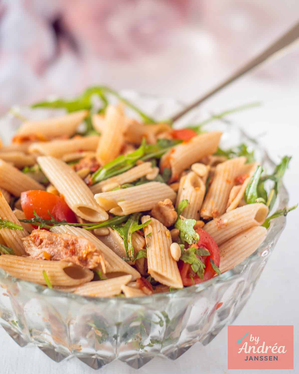 Een glazen schaal gevuld met Penne met Gerookte Makreel en Cherrytomaten