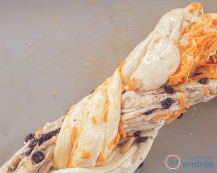 Three types of dough flavors braided into a strand on a gray background