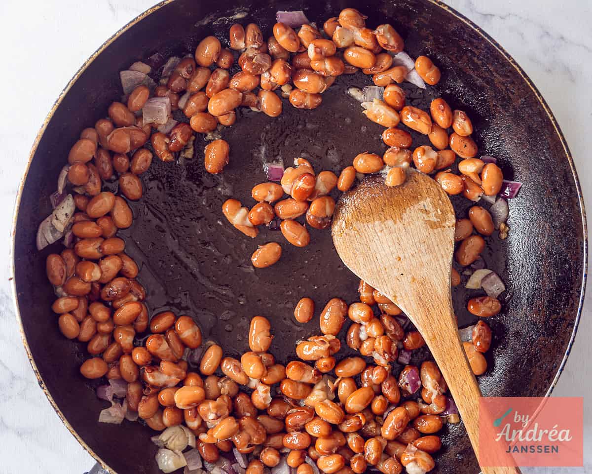 Frying kidney beans, onion and garlic in a skillet