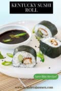 A section of a white plate with sushi rolls with chicken and cucumber. The text reads: Kentucky Sushi Roll