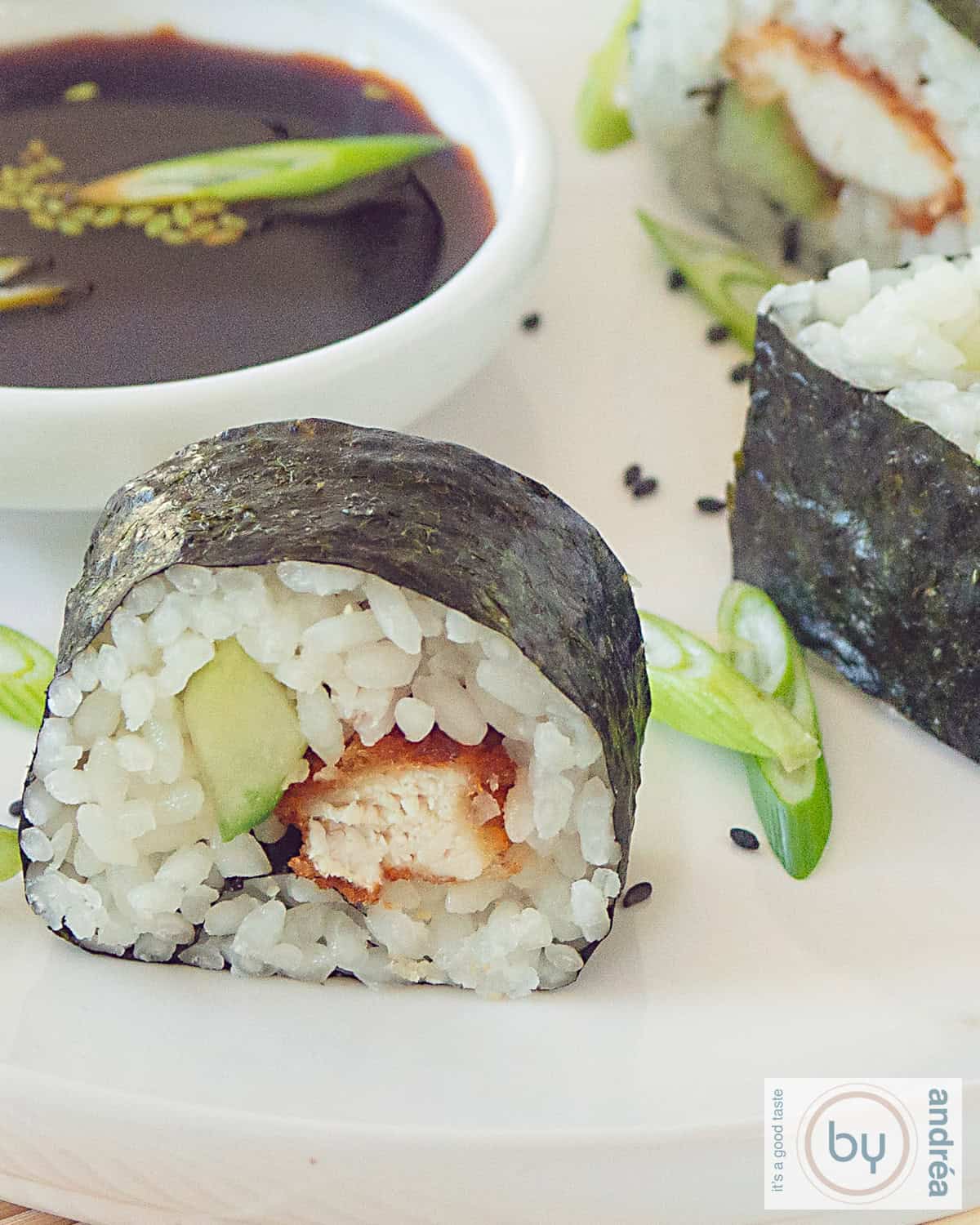 Een macro opname van een sushi roll met crispy kip en komkommer. Sojasaus in de achtergrond.