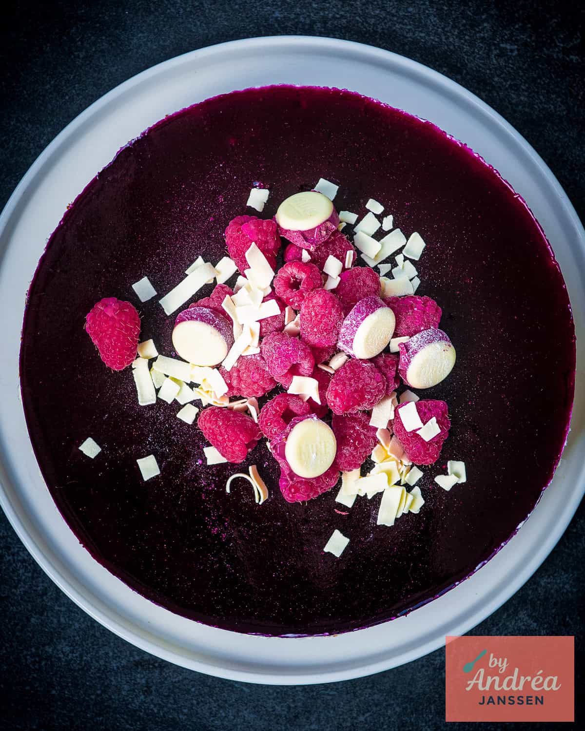 A picture from above of a white chocolate cheesecake with forest fruits.