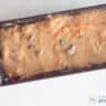 Beslag wortelcake in een cakeblik op een witte ondergrond