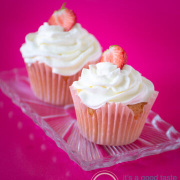 two strawberry cupcakes on a glass plate