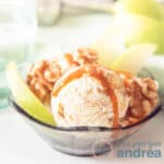 A square photo of a bowl with ice cream, apples, walnuts on a white background