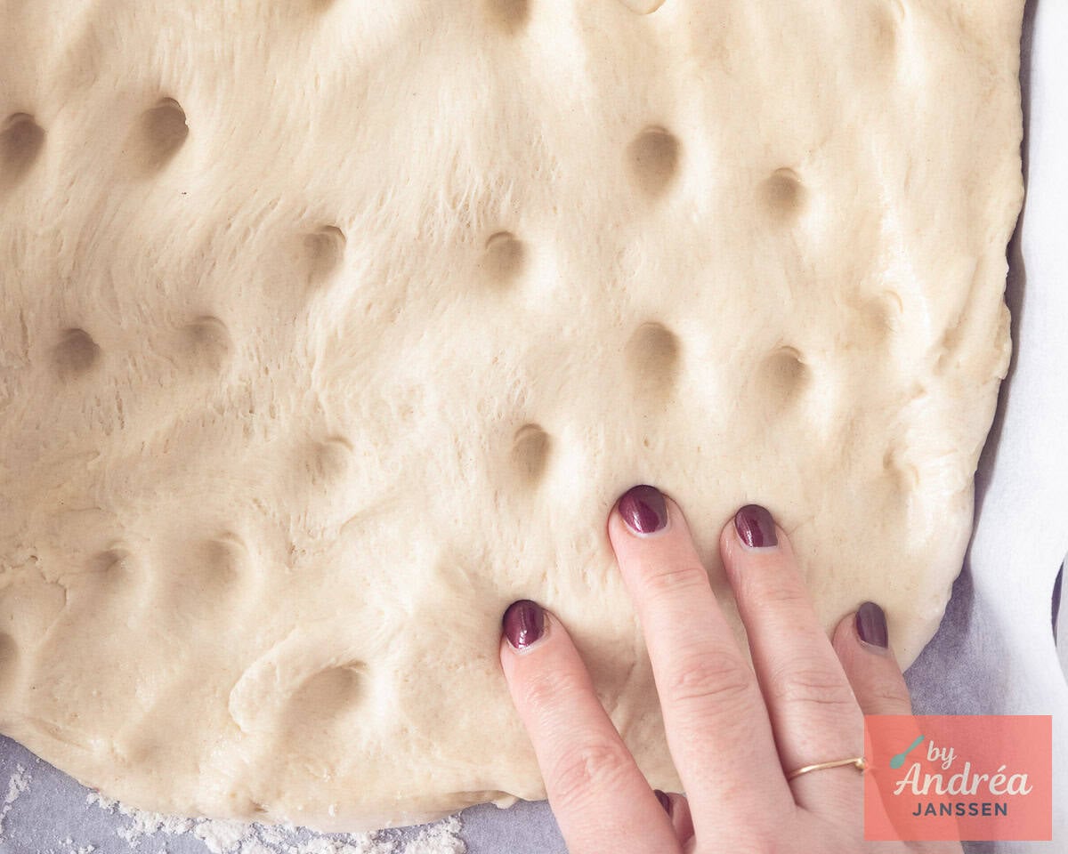 Met de vingers worden gaten geduwd in het deeg.