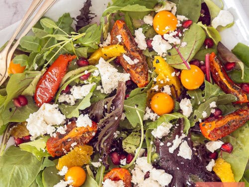 A square photo of a salad with feta, golden berries, sun-dried tomatoes and orange
