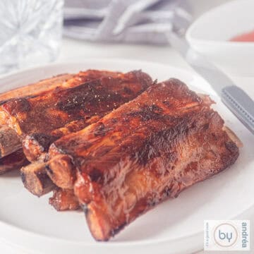 A square photo of a plate with a stack of honey kecap whisky ribs.
