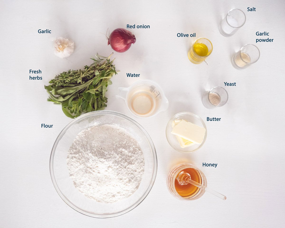 Ingredients Focaccia Bread With Garlic Butter Herbs on a white background with text description