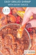 A glass filled with satay sauce in which a shrimp is dipped. A text: easy recipe, easy grilled shrimp with satay sauce
