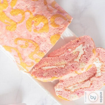 A square photo from above of a Swiss roll cake with whipped cream filling