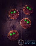 4 Halloween cupcakes with sprinkles and M&M's and some spiders