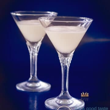 Two crystal glasses filled with sour sherry cream on a blue background.