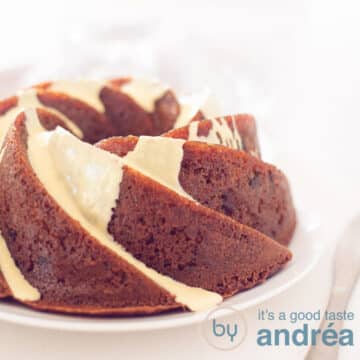 A square photo with part of a cranberry turban with white chocolate sauce. On a white plate on a white background. A golden knife lies to the right of it.