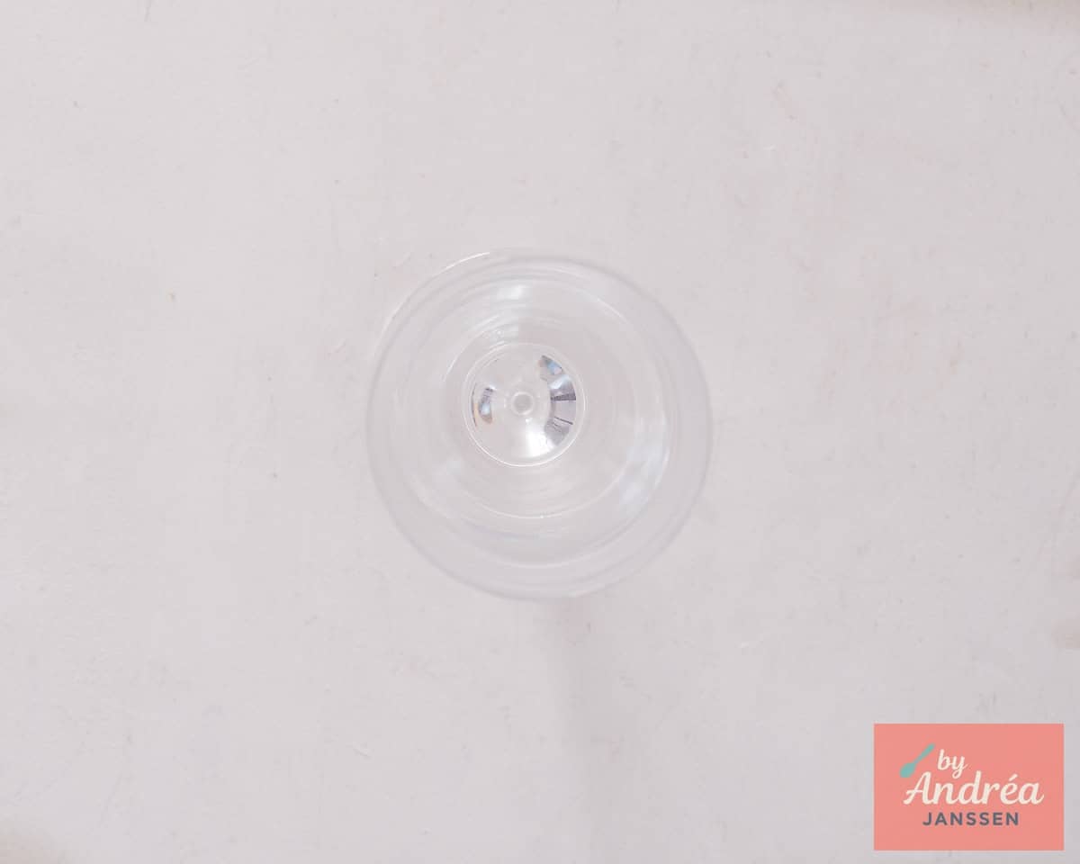 A chilled champagne glass stands ready on a white background.