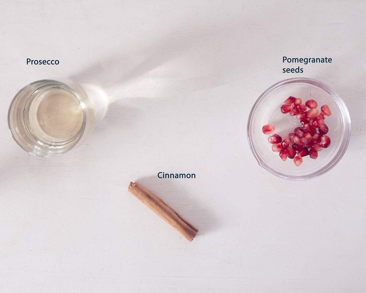 Ingredients Pomegranate Prosecco Cocktail with Cinnamon on a white background with a text description