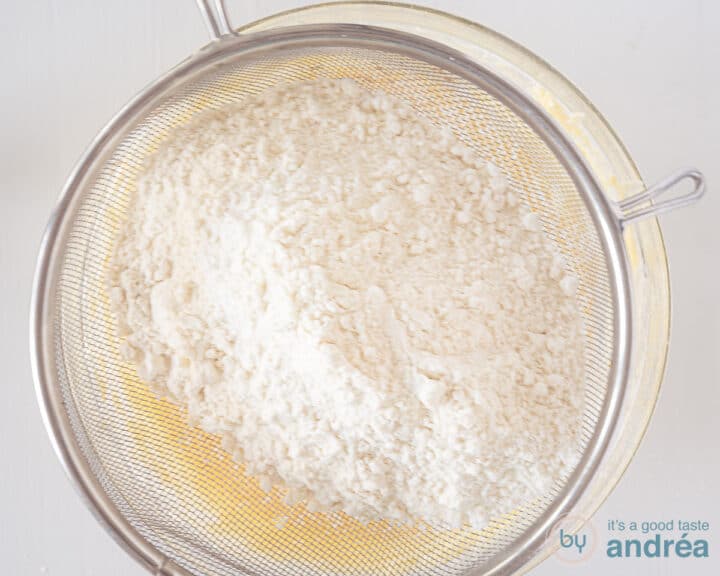 Sift the flour over the glass bowl with batter.