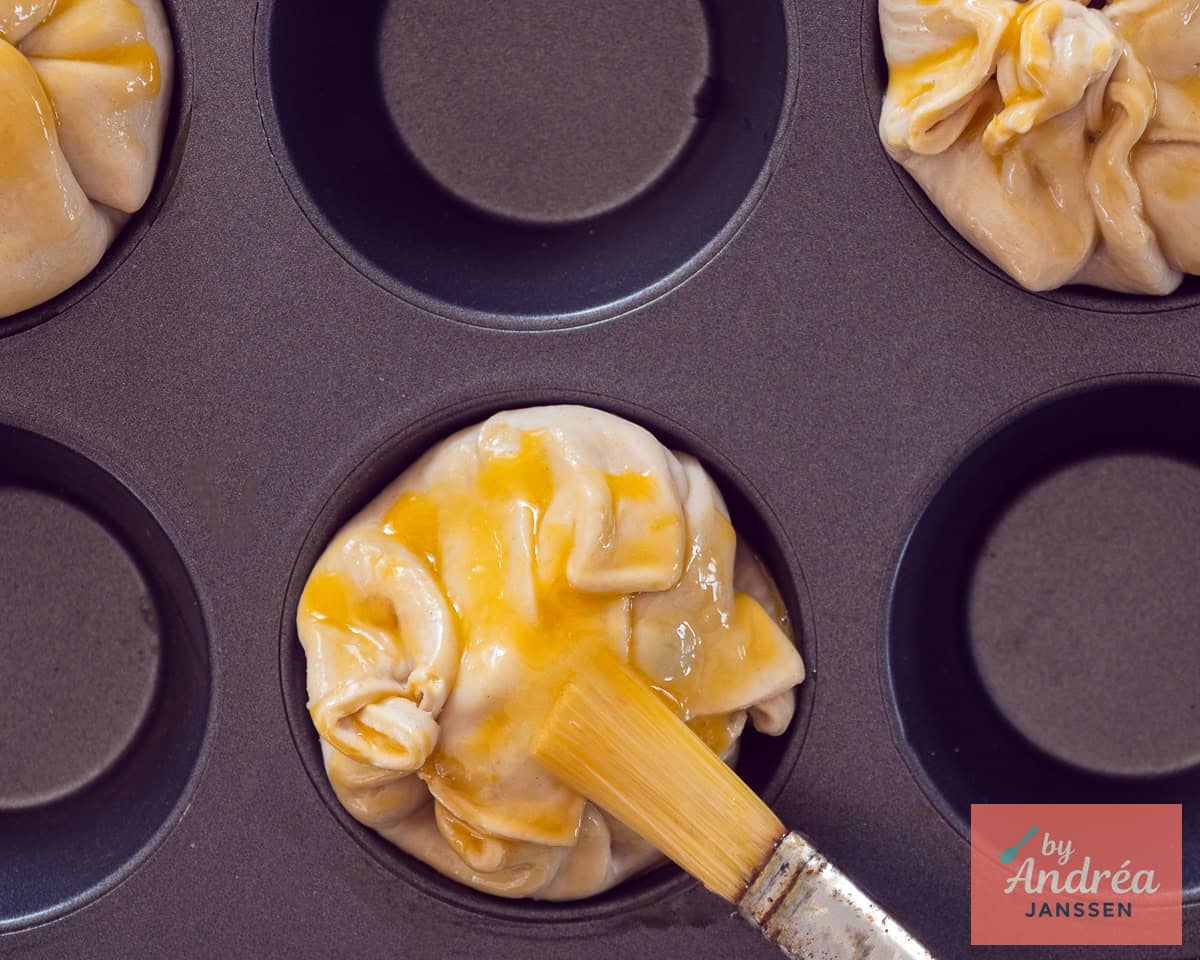 Fold pastry over the filling and prick the tops with a fork. Brush egg wash over the pastry tops before baking
