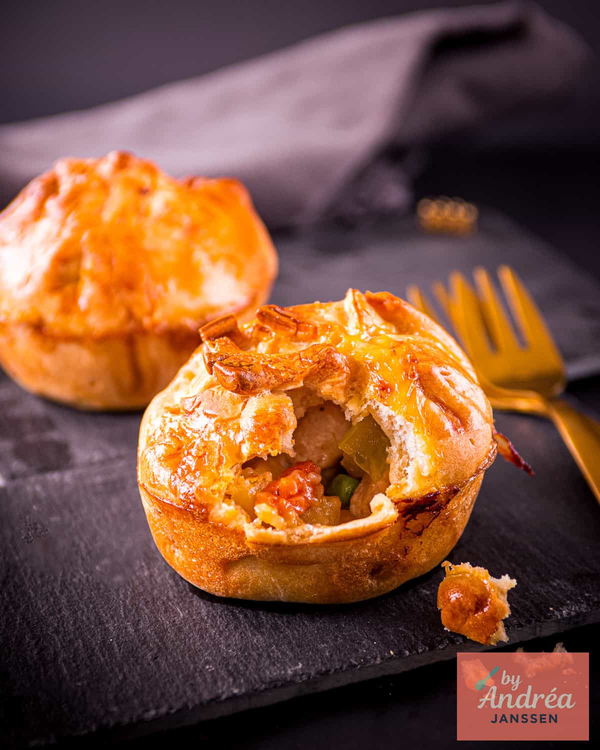 Chicken pot pie muffins with golden pastry tops in a muffin tin