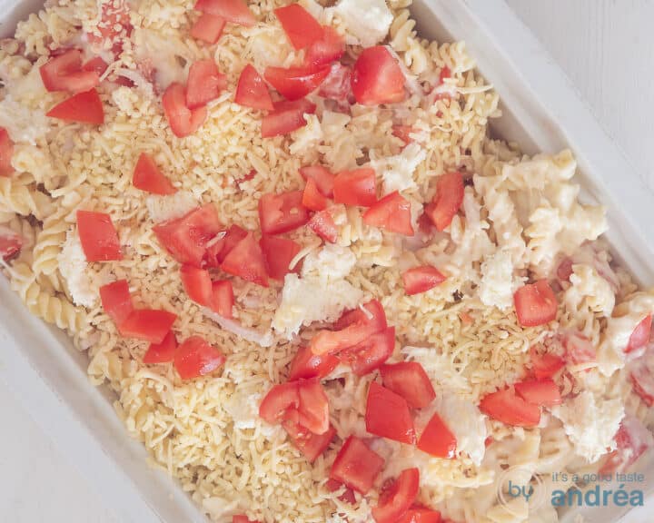 A pasta casserole from above with fresh pieces of tomato.