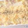 A width photo showing an oven dish with mashed potatoes sprinkled with panko, grated cheese and thyme