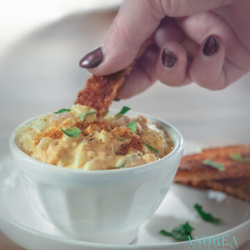 a slice of toast with a bowl of egg salad