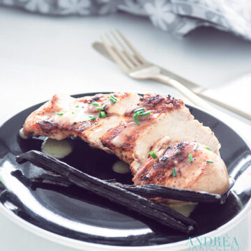 Chicken with vanilla sauce on a black plate