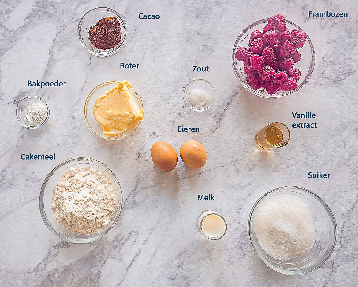 Ingredienten Chocolade Frambozencake op een wit marmeren ondergrond met tekstbeschrijving