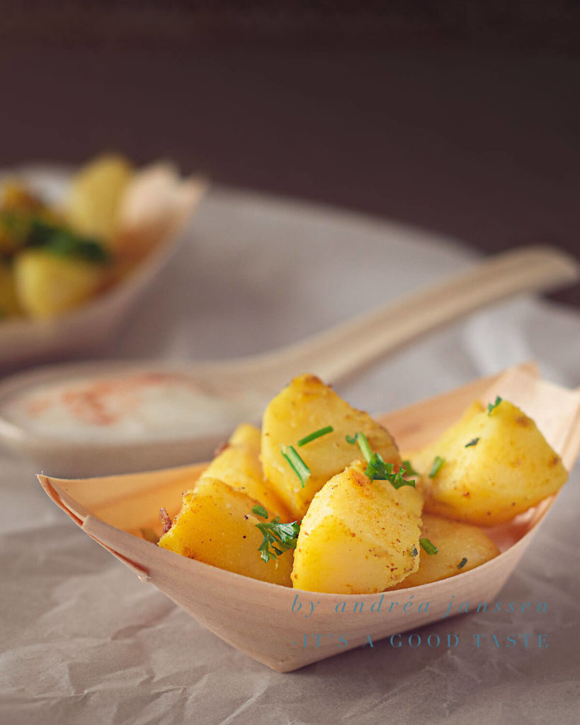 Baked potatoes with green herbs and garlic yogurt sauce