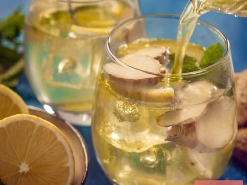 A square photo with two glasses filled with homemade ginger iced tea. One glass is being filled.