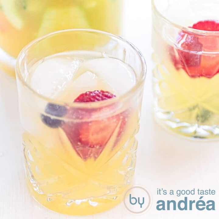 A square photo of a glass filled with a fruity Sprite mocktail. A second glass is partially angled behind it.