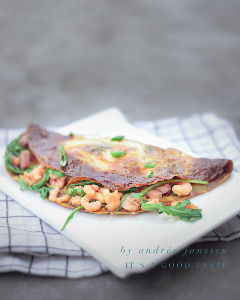 een bord met een omelet en garnalen