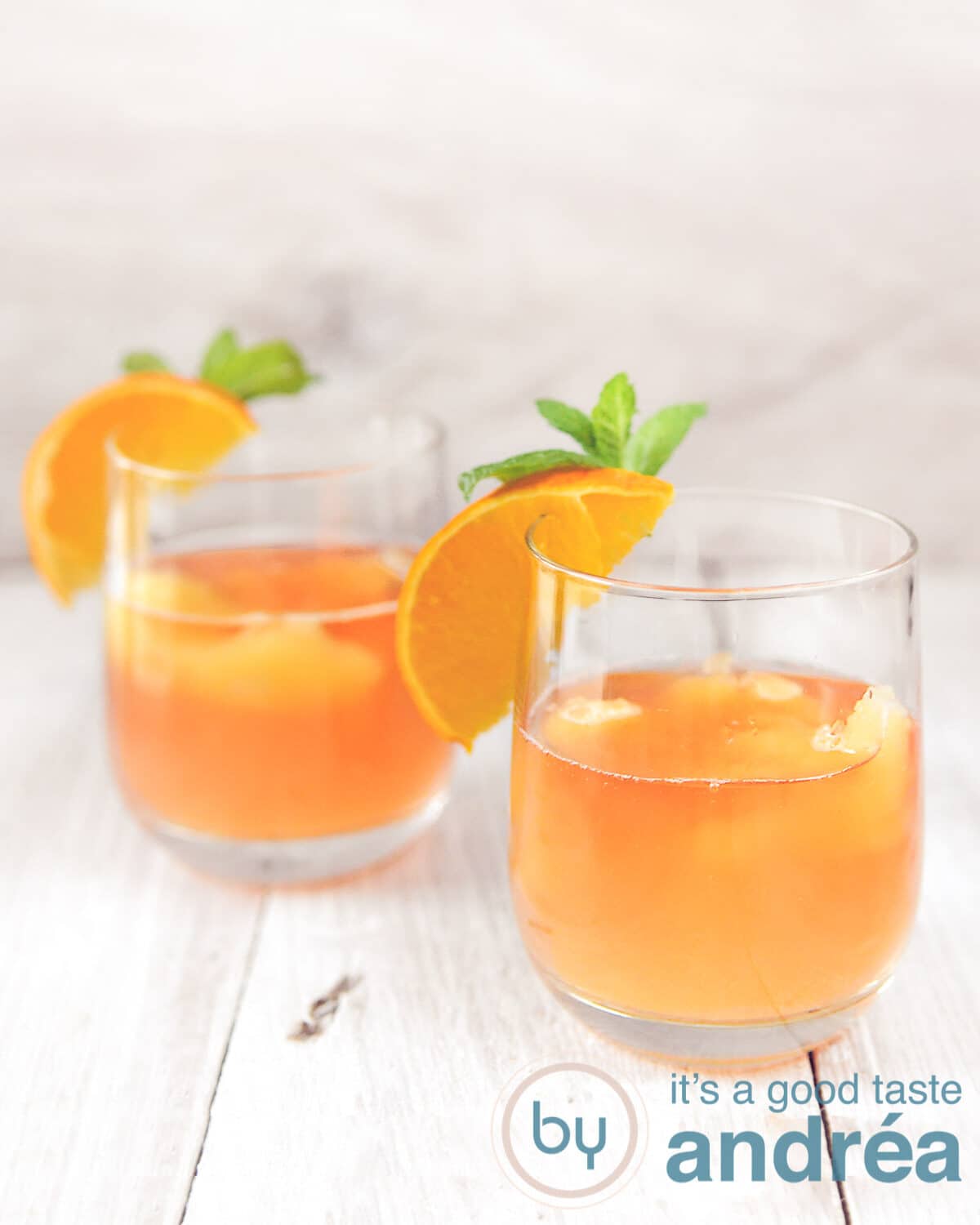 Orange cocktail in two glasses with oranges