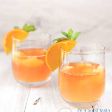 Orange cocktail in two glasses with oranges