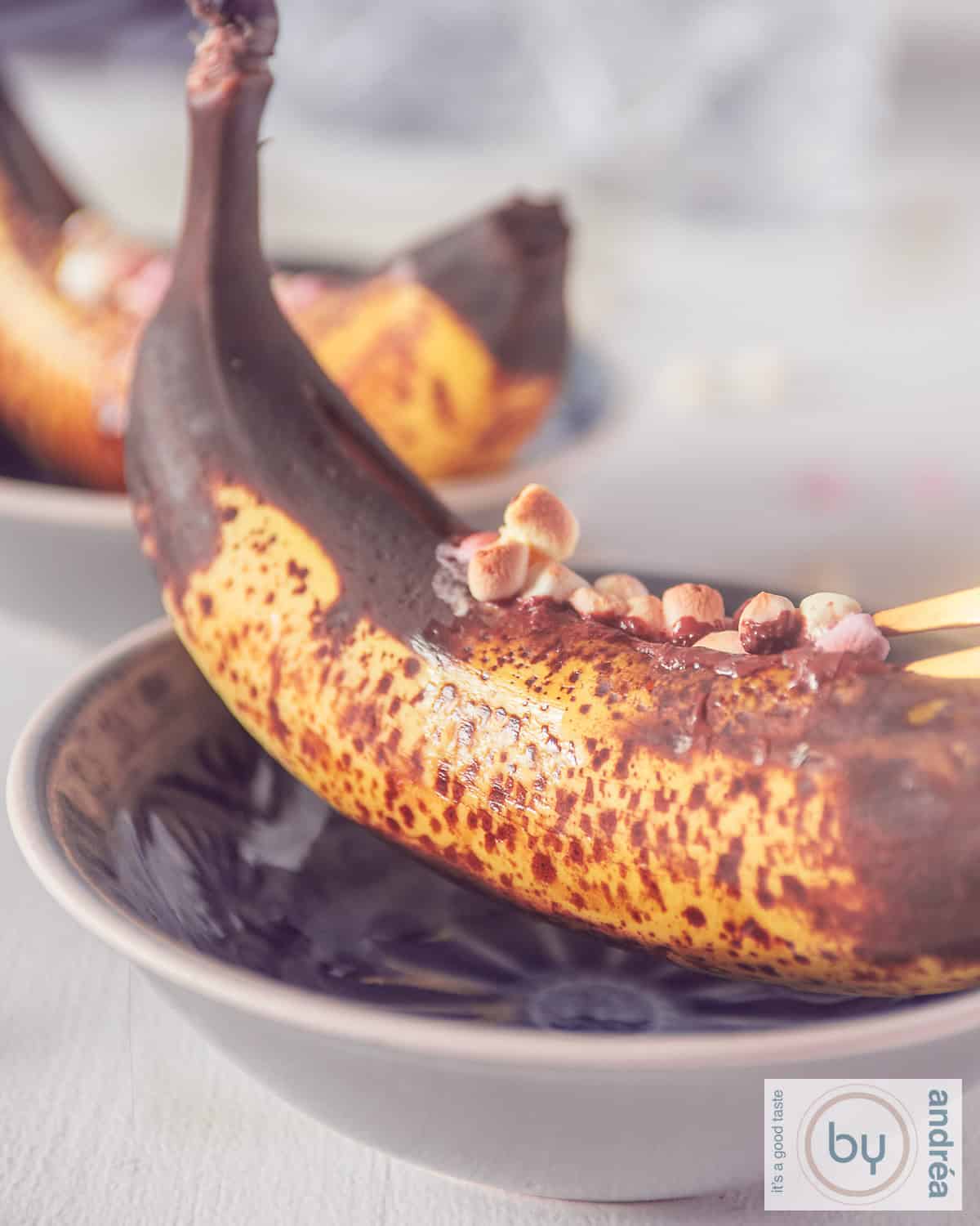 Een hoogtefoto met twee schaaltjes met gegrilde banaan met whisky, marshmallows en chocola.