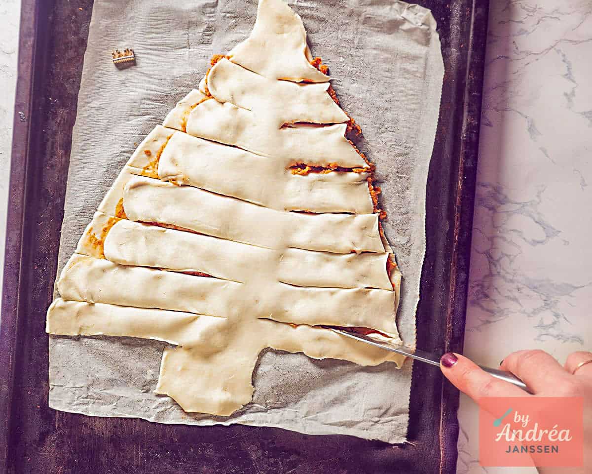 Brush puff pastry Christmas tree filled with red pesto with egg