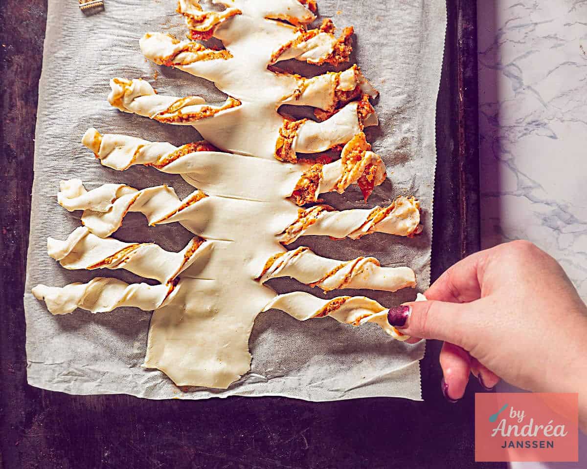 The 'branches' of the puff pastry Christmas tree are rolled up.