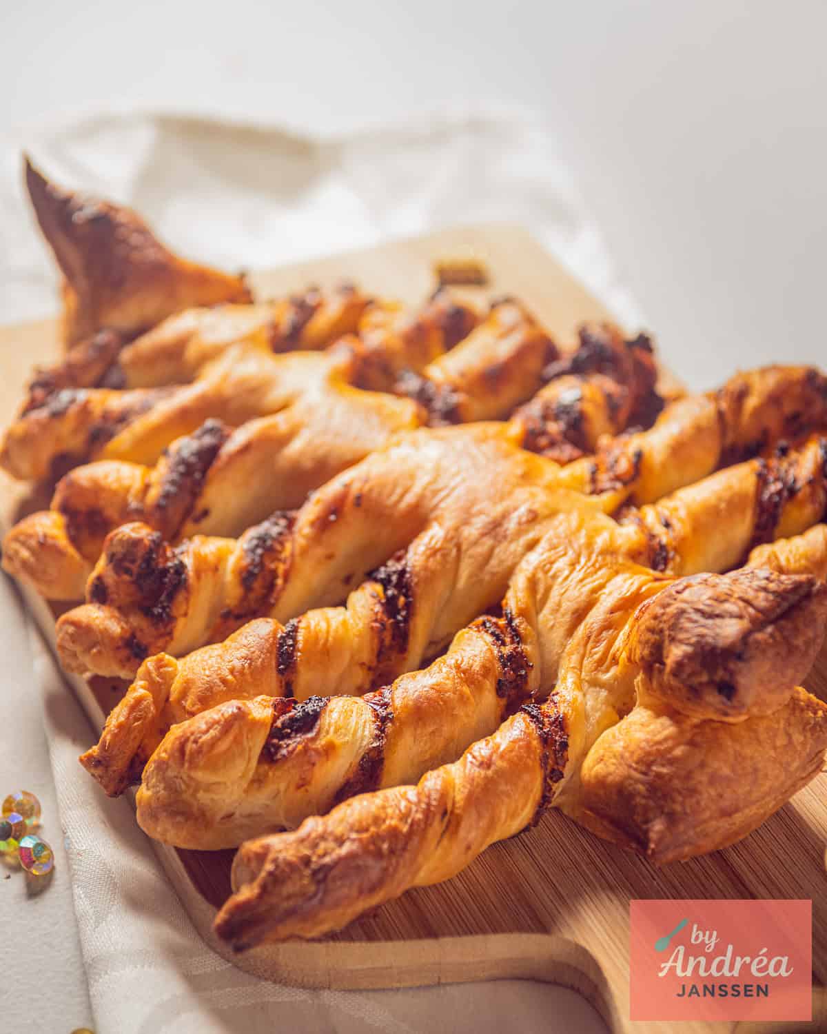 A puff pastry Christmas tree filled with red pesto on baking paper