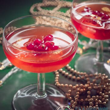 Two glasses filled with Cosmopolitan cocktail recipe with red currants