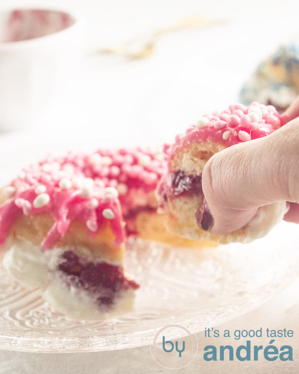 a hand grabbing a piece of filled donut