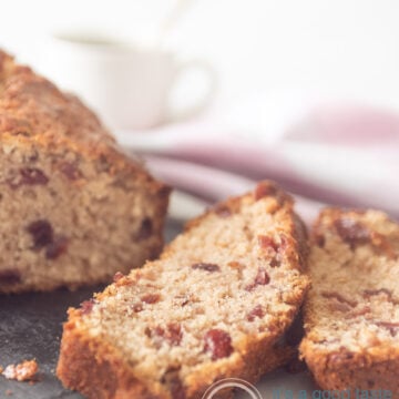 a cranberry walnut coffee cake on a silver platter. Two slices cut off.