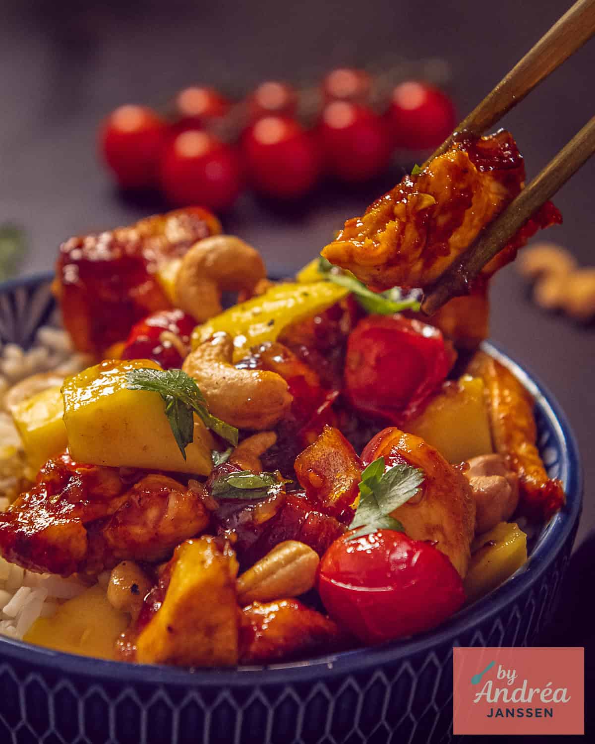 An height picture of chicken, mango and tomato in a rich honey soy sauce