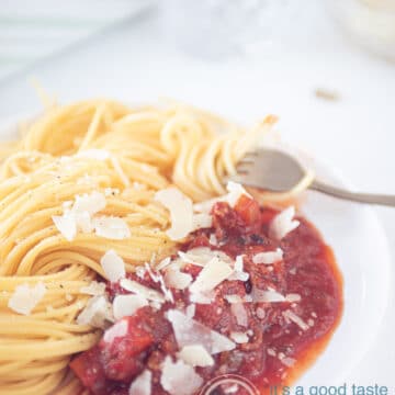 slowcooker pasta sauce with ground beef on a white plate with some spaghetti