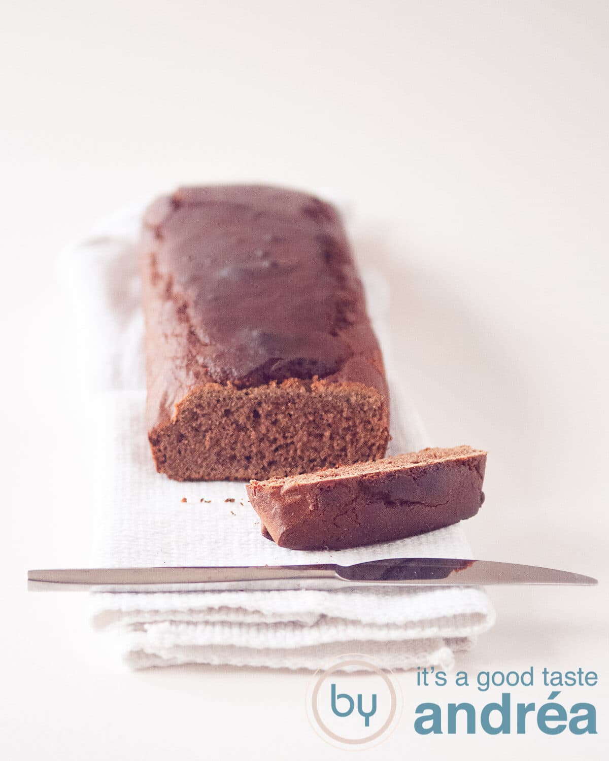 an ontbijtkoek cake on a cloth with one slice cut off