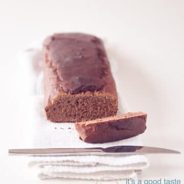 an ontbijtkoek cake on a cloth with one slice cut off