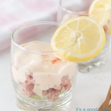 a glass with shrimp, whiskey cocktail sauce and ice berg lettuce