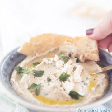 a hand taking a bite of the Melitzanosalata dip